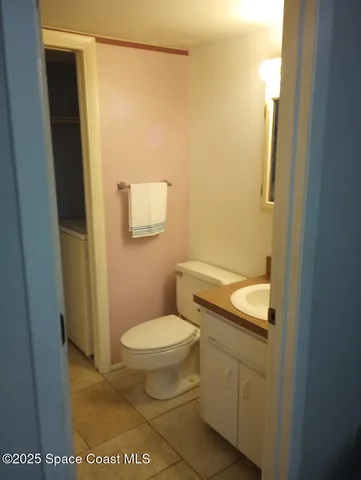 a bathroom with a granite countertop toilet and a sink