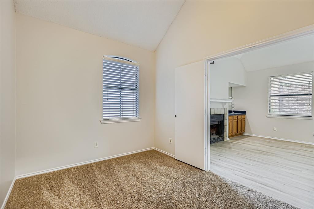 4319 Harvest Hill Road Carrollton, TX 75010 - Photo 14 of 28 Spare room featuring lofted ceiling, light carpet, plenty of natural light, and a tile fireplace
