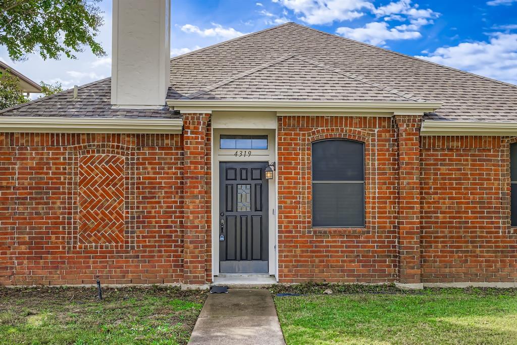 4319 Harvest Hill Road Carrollton, TX 75010 - Photo 4 of 28 Entrance to property with a shingled roof, brick siding, and a yard