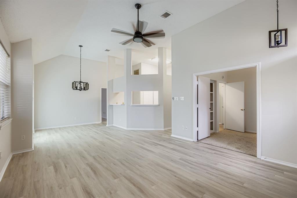 4319 Harvest Hill Road Carrollton, TX 75010 - Photo 6 of 28 Unfurnished living room featuring light wood-style floors, high vaulted ceiling, a ceiling fan, and a chandelier