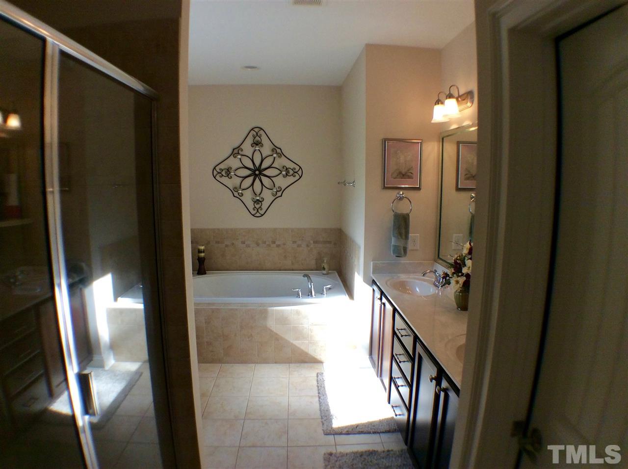 12811 Edsel Drive Raleigh, NC 27613 - Photo 14 of 25 a bathroom with a bathtub and a shower