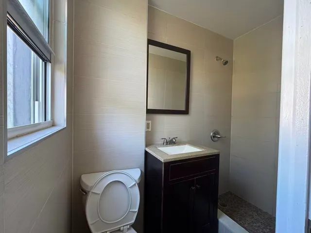 a bathroom with a toilet a sink and mirror