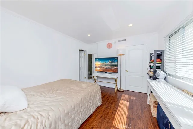 a bedroom with a bed and a flat screen tv