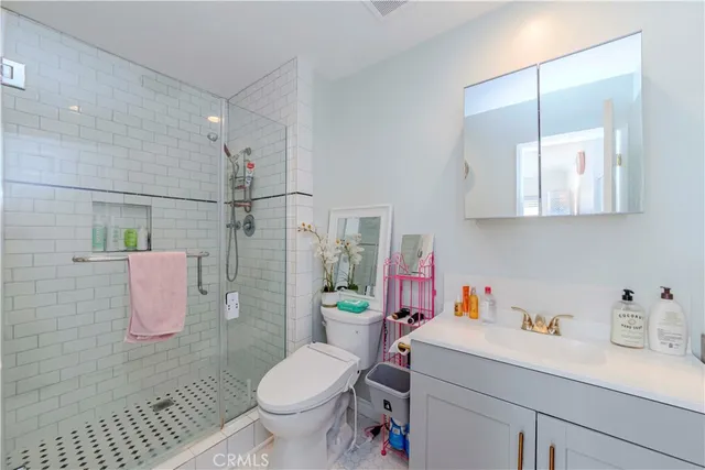 a bathroom with a sink toilet vanity and shower
