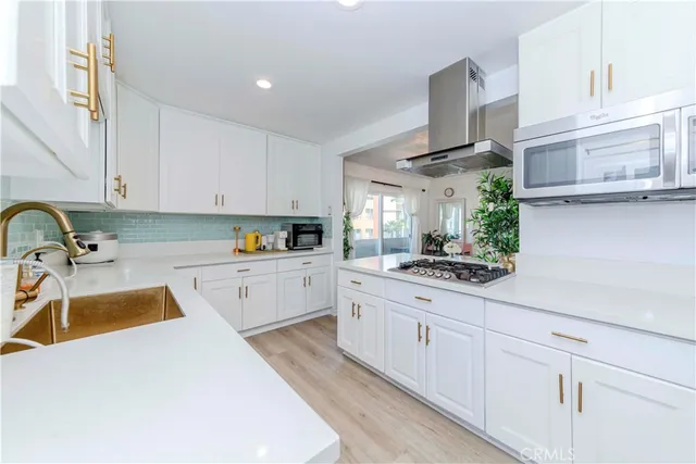 a kitchen with granite countertop a sink stainless steel appliances and cabinets