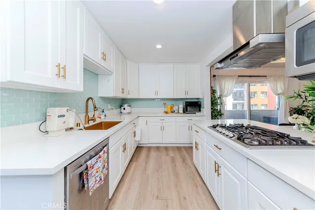 a kitchen with a sink a stove and cabinets