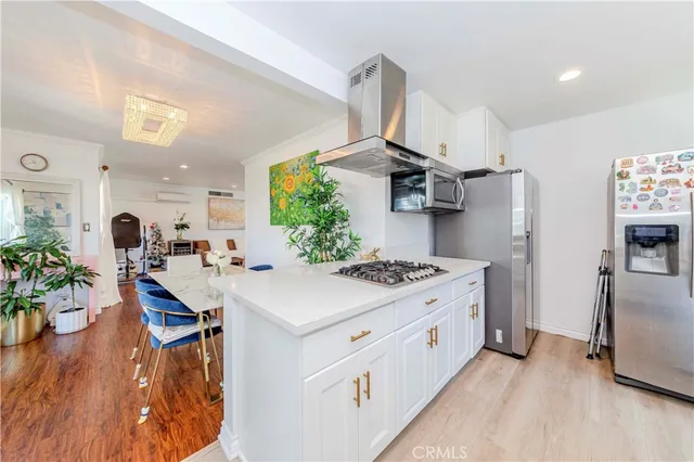a kitchen with a sink appliances and wooden floor