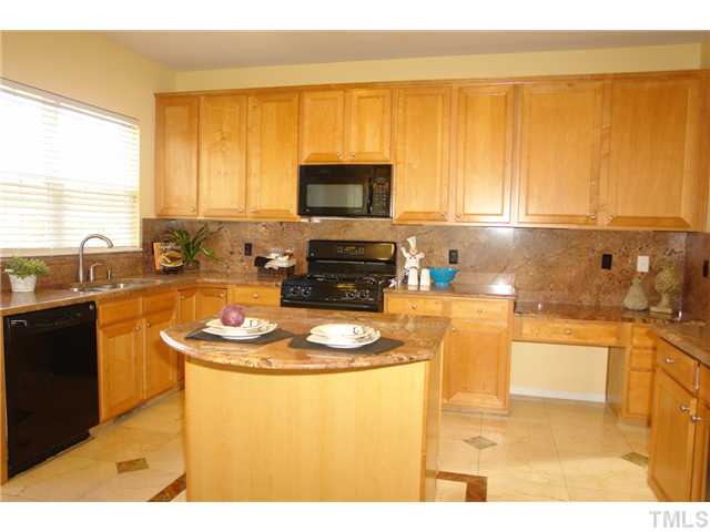 7734 San Gabriel Street Raleigh, NC 27613 - Photo 5 of 25 a kitchen with a sink a stove and a microwave