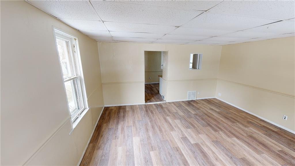 1112 Webster Street Farrell, PA 16121 - Photo 2 of 20 an empty room with wooden floor and windows