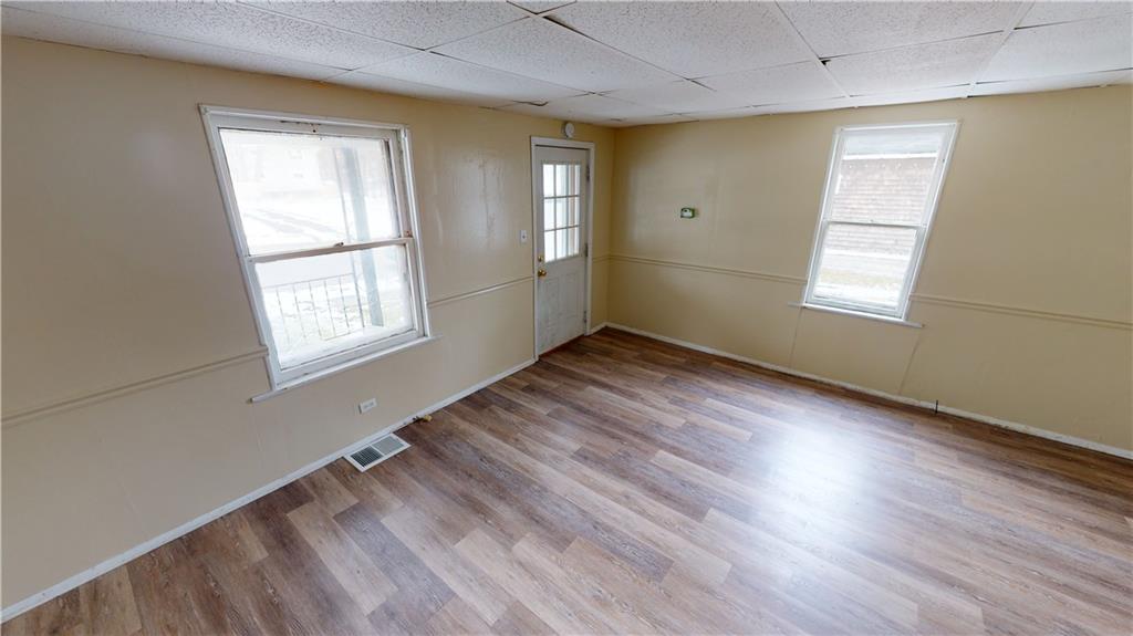 1112 Webster Street Farrell, PA 16121 - Photo 4 of 20 a view of an empty room with wooden floor and a window