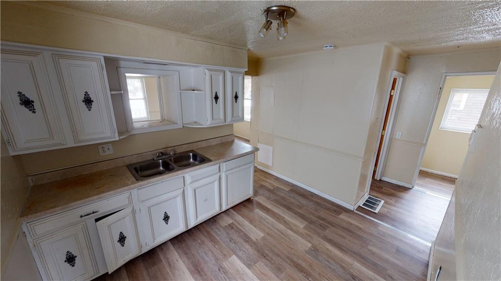 1112 Webster Street Farrell, PA 16121 - Photo 5 of 20 a kitchen with granite countertop white cabinets and wooden floor