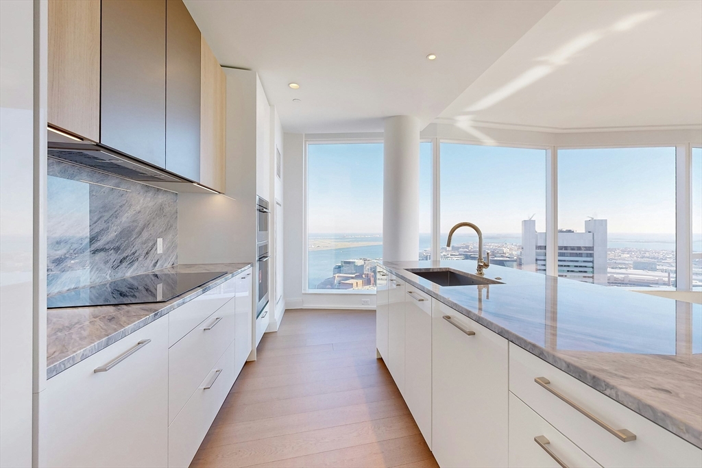 a large kitchen with kitchen island a sink and a large window