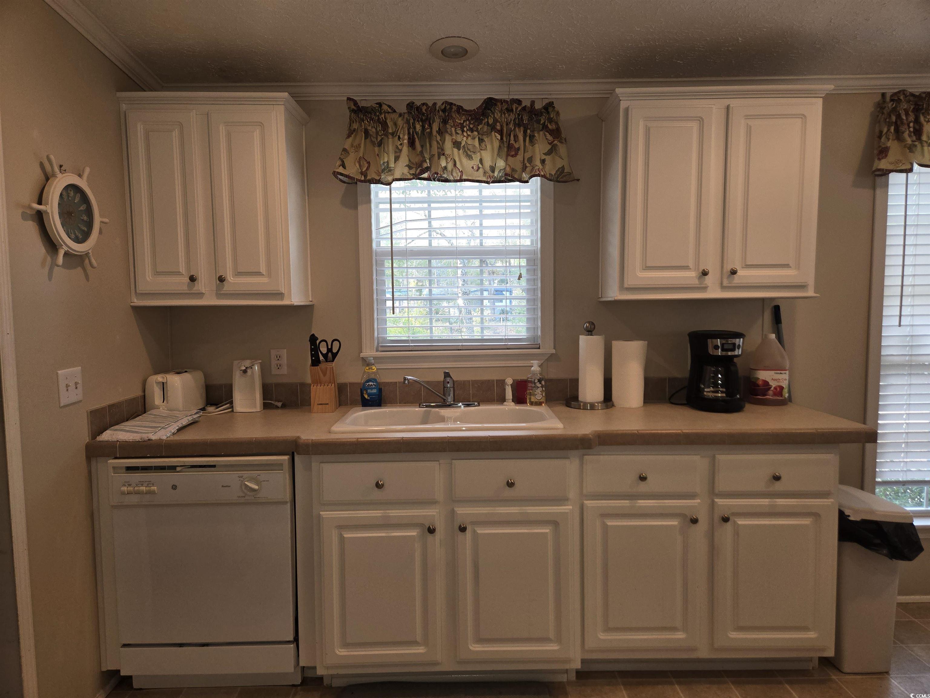 361 East Canal Street Murrells Inlet, SC 29576 - Photo 12 of 35 Kitchen with white cabinetry, a sink, light countertops, dishwasher, and crown molding