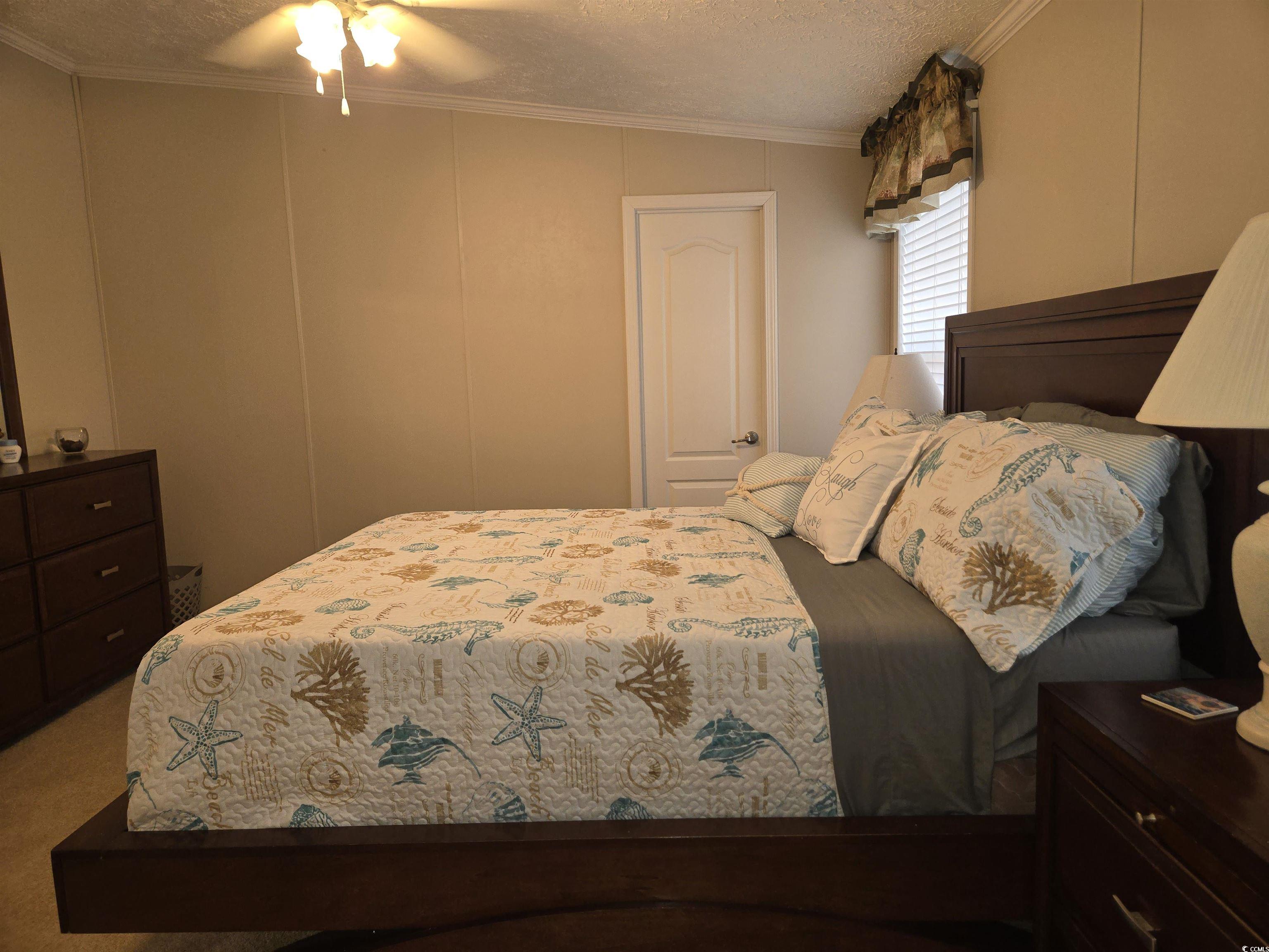 361 East Canal Street Murrells Inlet, SC 29576 - Photo 14 of 35 Carpeted bedroom with a textured ceiling, ceiling fan, crown molding, and a decorative wall