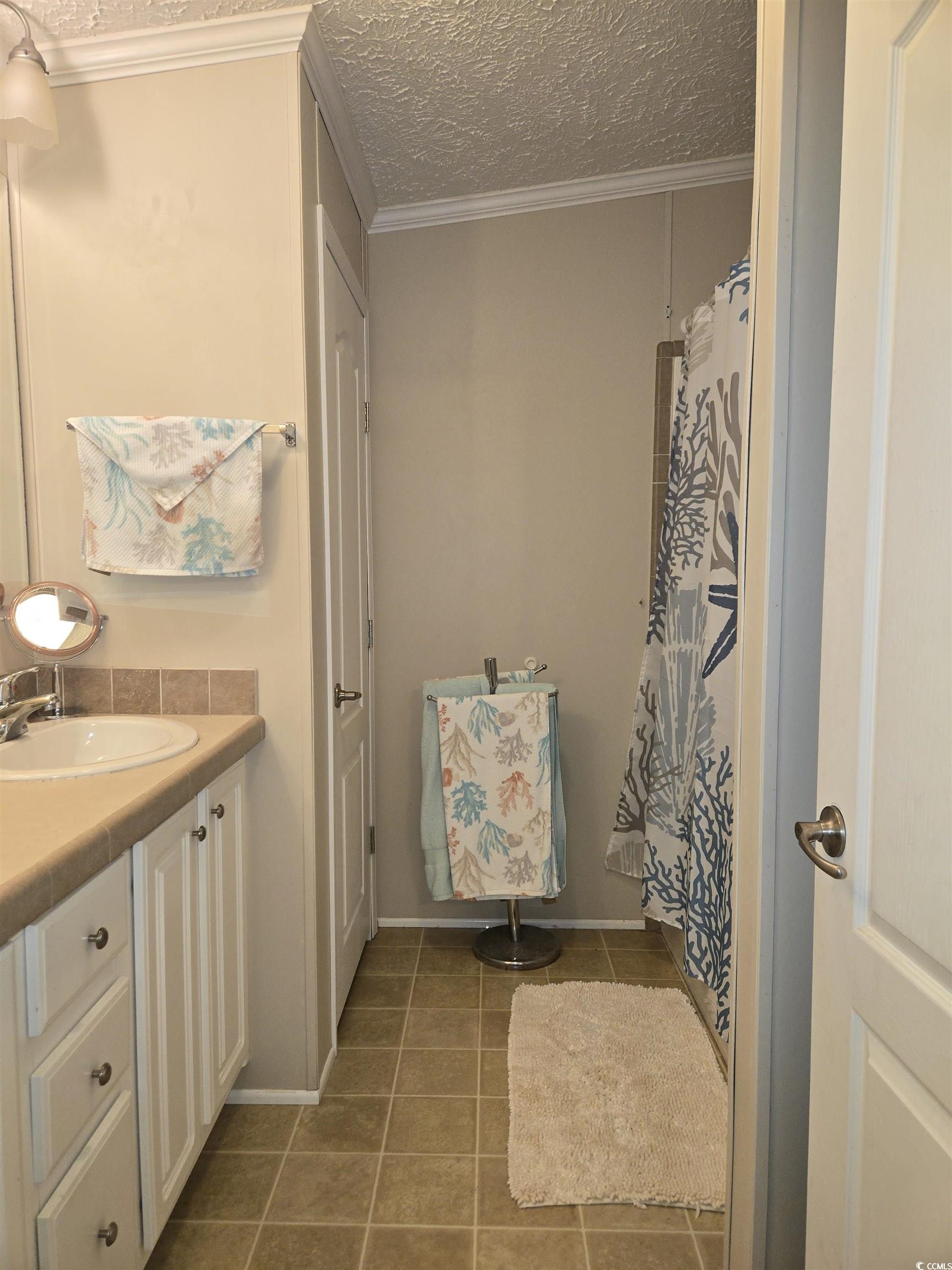 361 East Canal Street Murrells Inlet, SC 29576 - Photo 21 of 35 Full bathroom with tile patterned floors, a textured ceiling, vanity, and ornamental molding