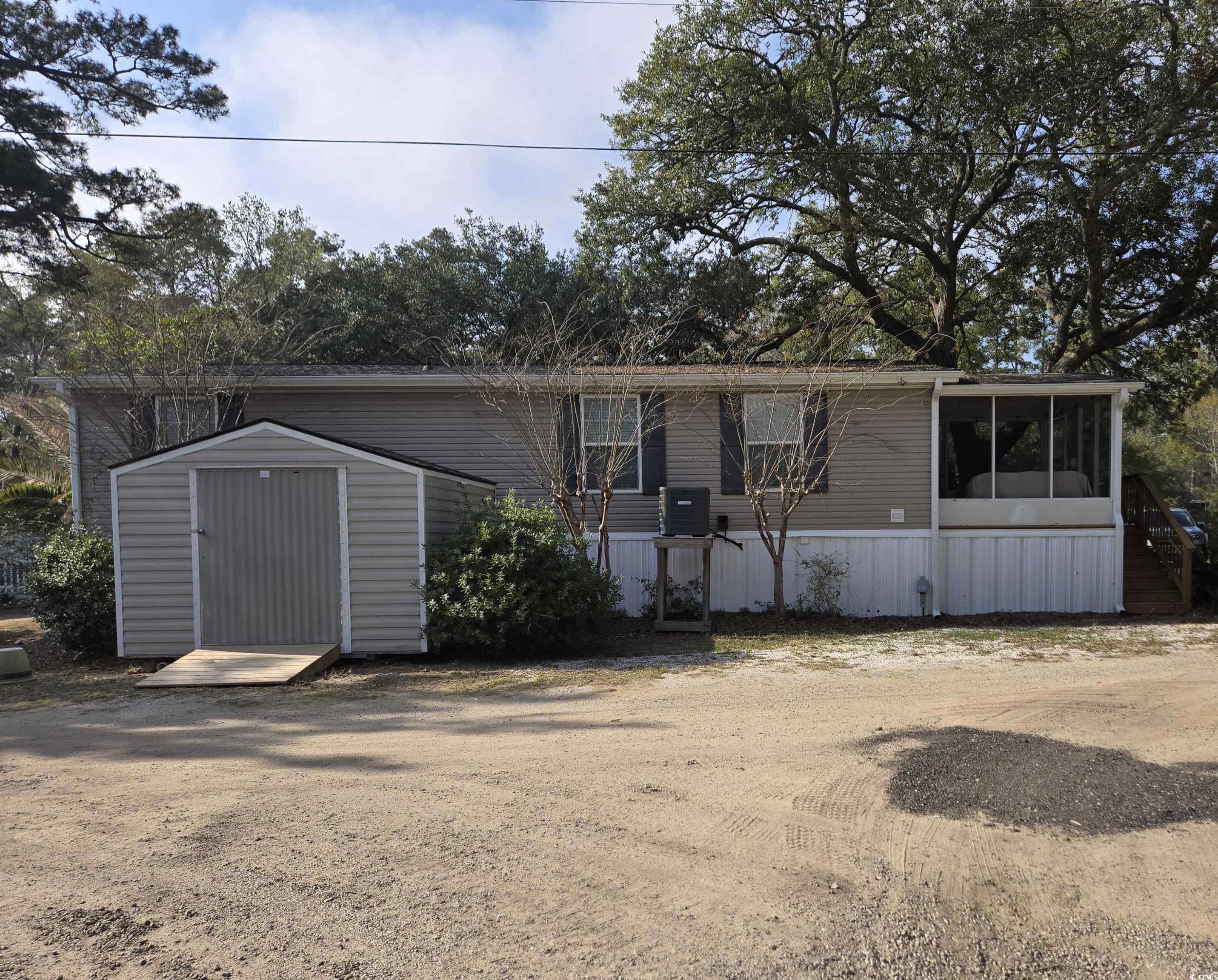 361 East Canal Street Murrells Inlet, SC 29576 - Photo 3 of 35 Manufactured / mobile home featuring an outbuilding, a storage shed, and a sunroom
