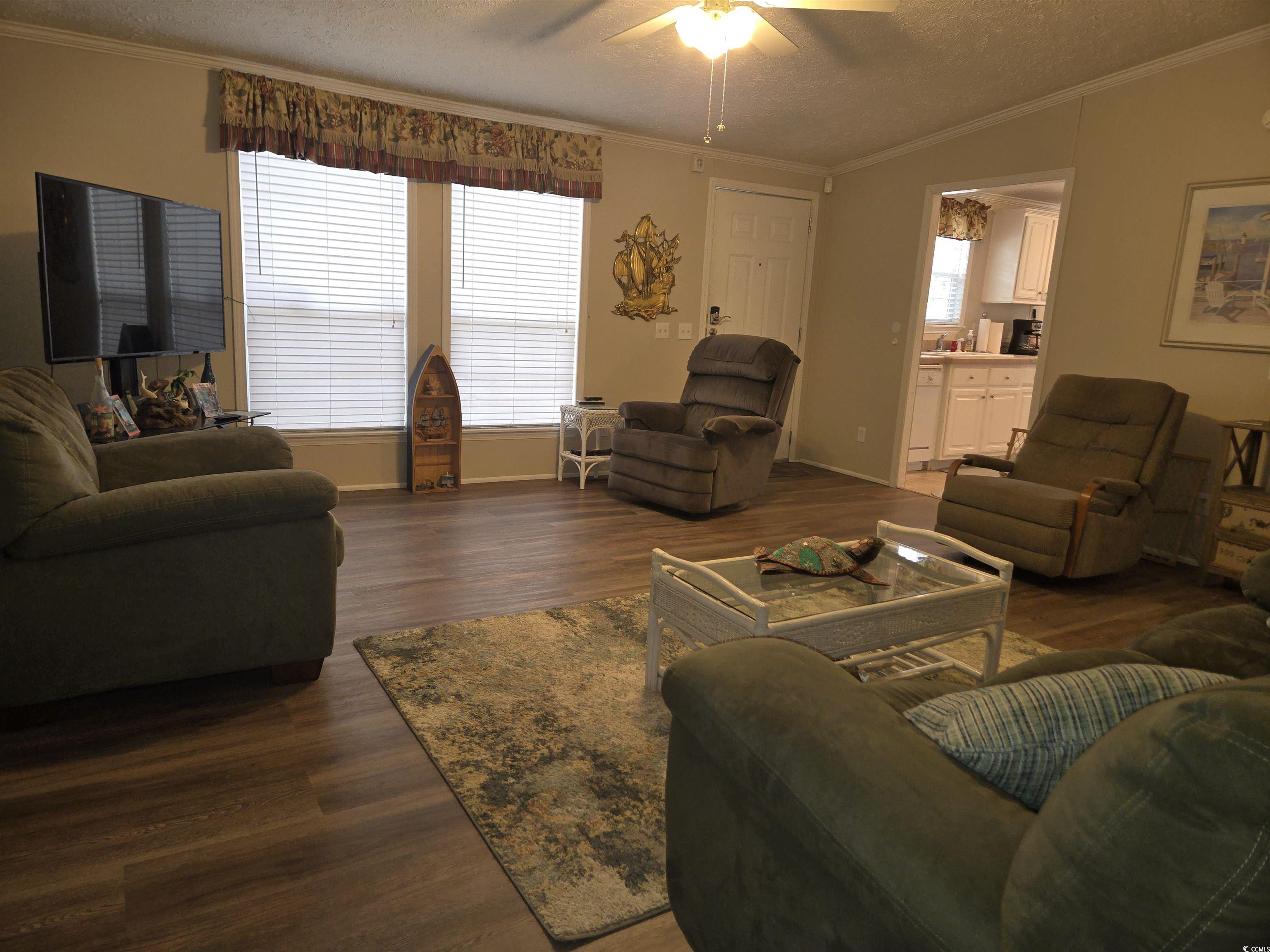 361 East Canal Street Murrells Inlet, SC 29576 - Photo 6 of 35 Living room featuring lofted ceiling, ornamental molding, and ceiling fan