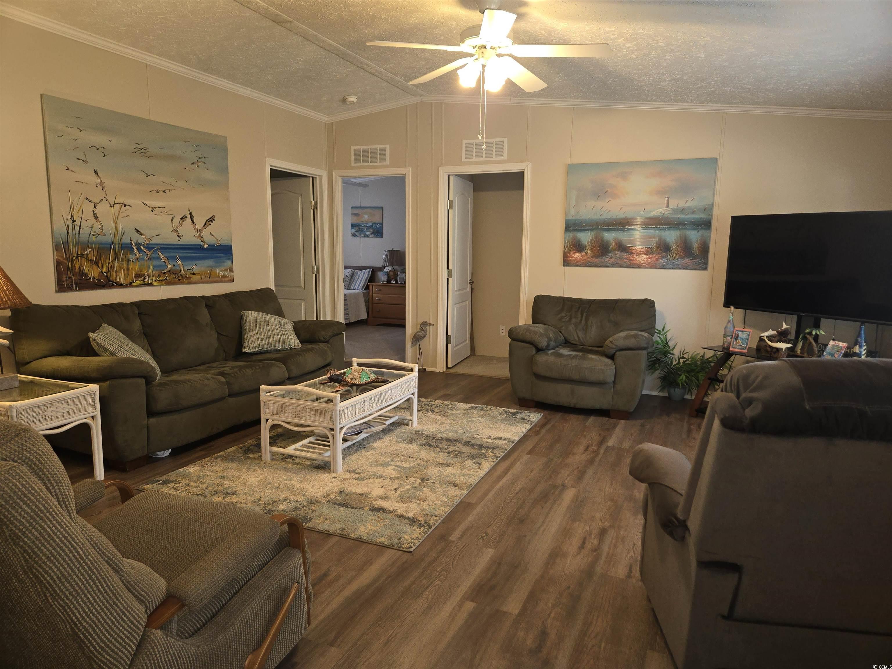361 East Canal Street Murrells Inlet, SC 29576 - Photo 7 of 35 Living area with lofted ceiling, wood finished floors, a ceiling fan, and visible vents