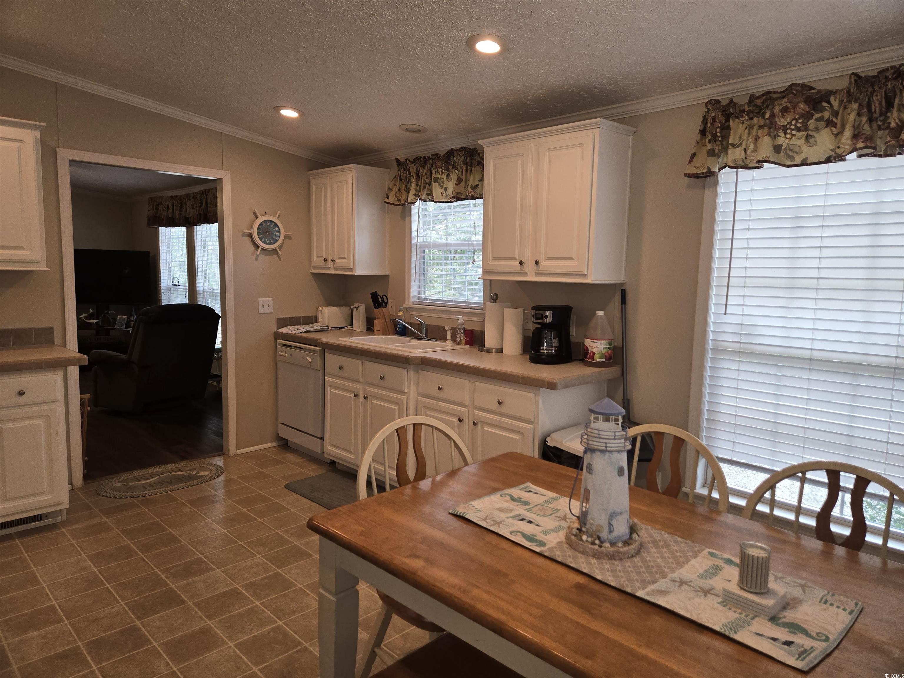 361 East Canal Street Murrells Inlet, SC 29576 - Photo 10 of 35 Kitchen with dishwasher, ornamental molding, white cabinetry, and a sink