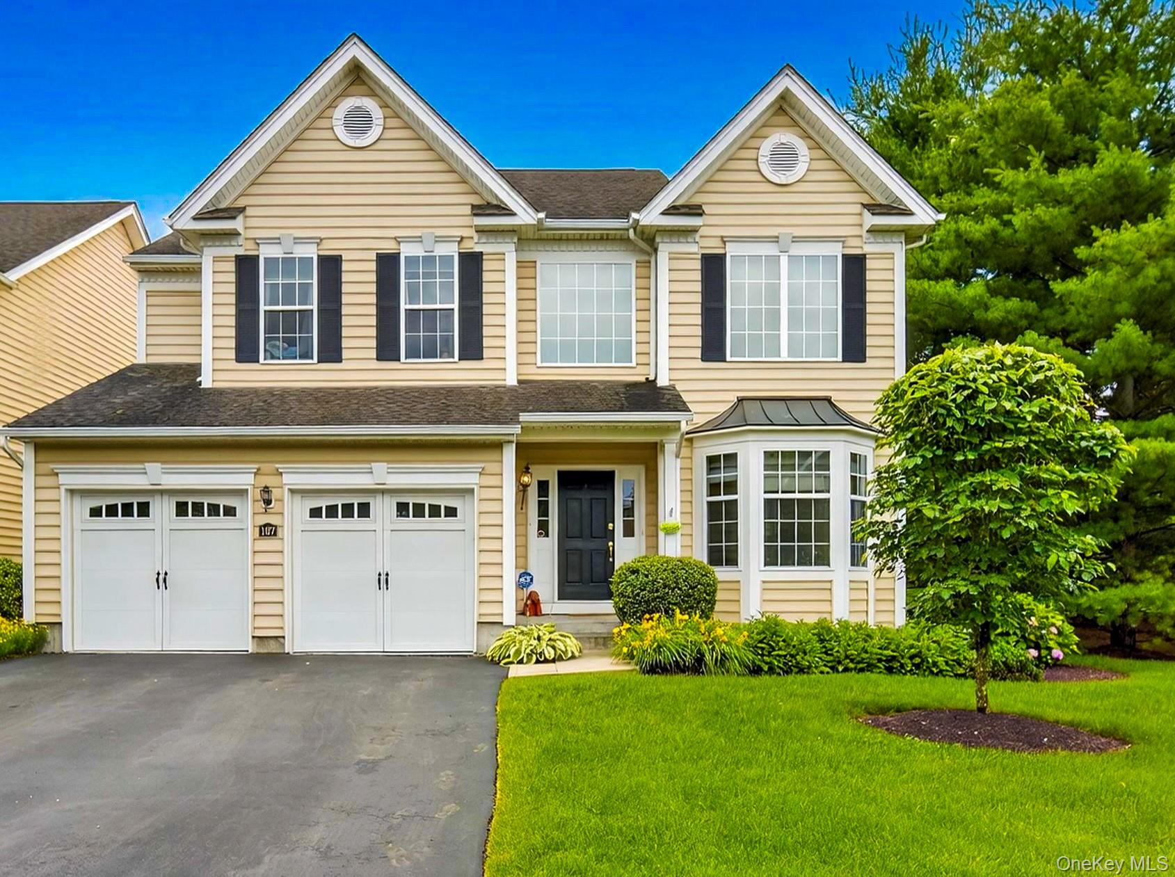 a front view of a house with a yard and trees