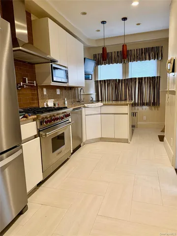 a kitchen with stainless steel appliances a stove a refrigerator and cabinets