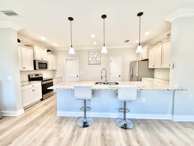 a view of kitchen with stainless steel appliances kitchen island sink refrigerator and stove
