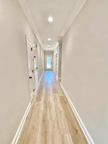 a view of a hallway with wooden floor and closet