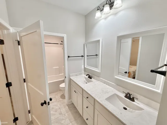 a bathroom with a double vanity sink mirror double shower and a bathtub