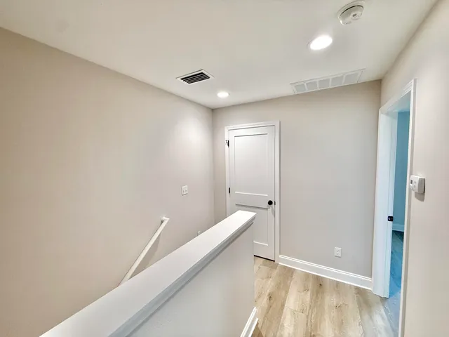 a view of hallway with stairs and wooden floor