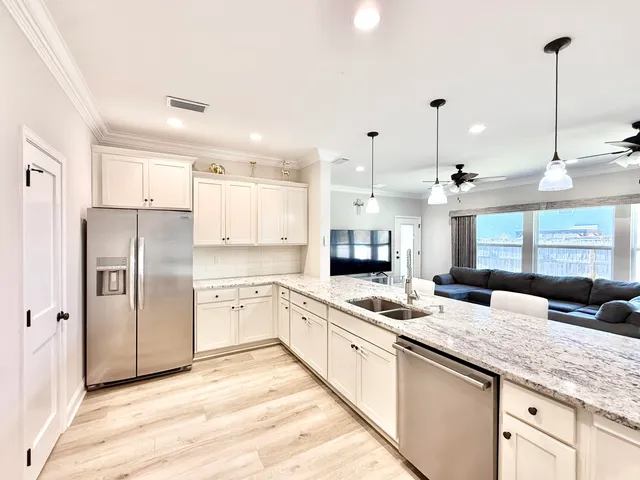 a kitchen with stainless steel appliances granite countertop a sink refrigerator and cabinets