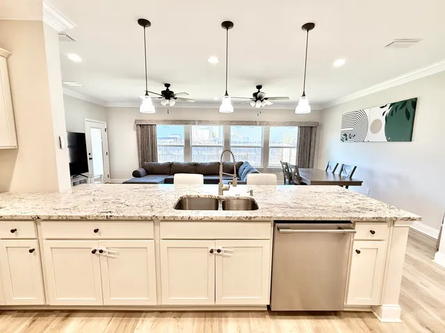 a view of a kitchen with kitchen island a sink stainless steel appliances and a counter top