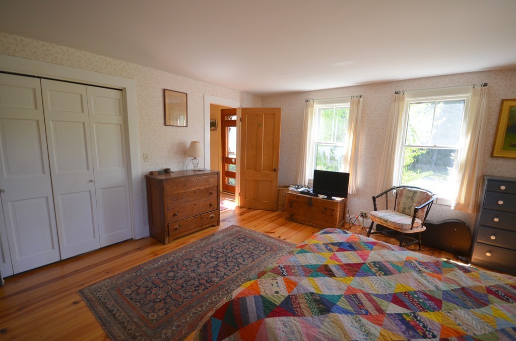 712 Pratt Corner Road Shutesbury, MA 01002 - Photo 12 of 30 a bedroom with a bed and wooden floor