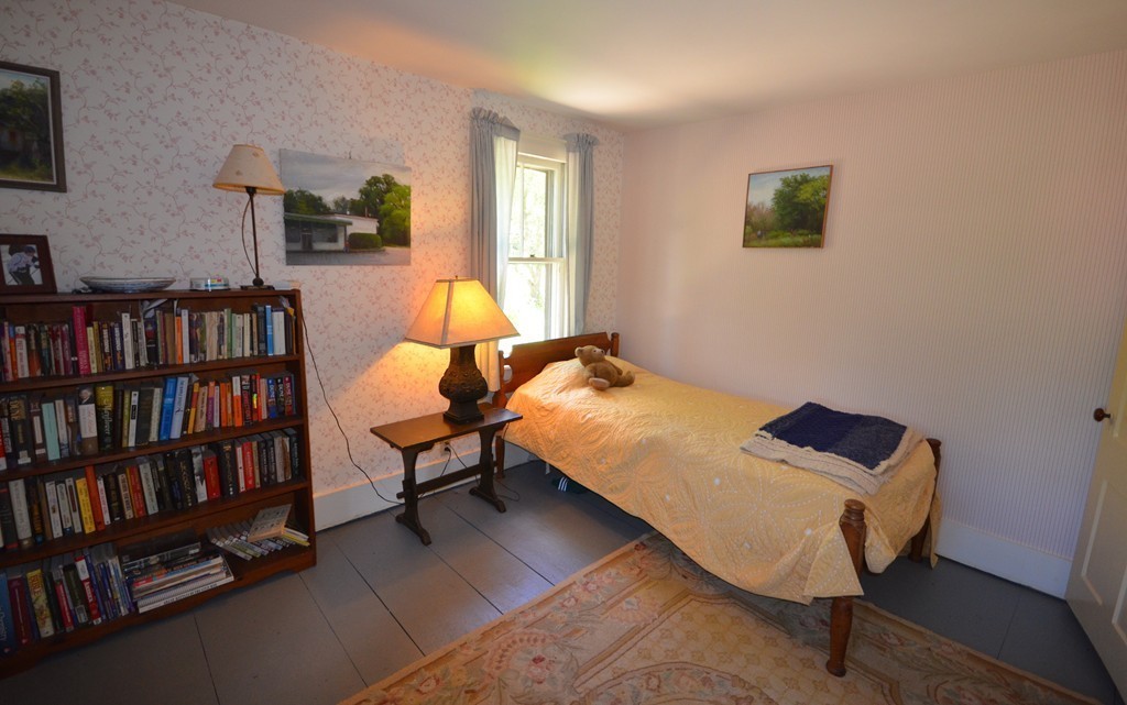 712 Pratt Corner Road Shutesbury, MA 01002 - Photo 14 of 30 a bedroom with a bed and a book shelf