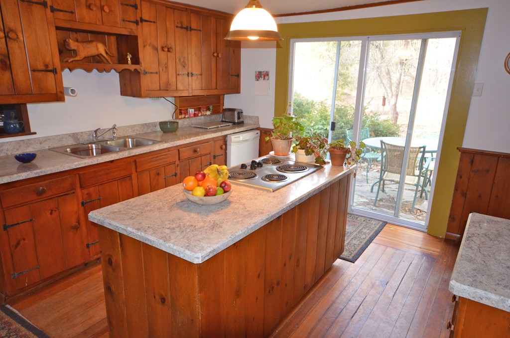 712 Pratt Corner Road Shutesbury, MA 01002 - Photo 8 of 30 a kitchen with a stove a sink a refrigerator wooden floor and a dining table