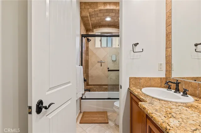 a bathroom with a granite countertop shower a sink and a mirror
