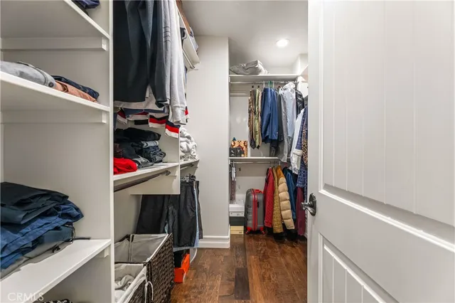 a view of walk in closet with clothes and shoes
