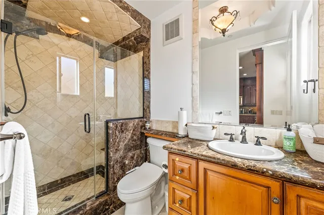 a bathroom with a granite countertop sink mirror vanity and toilet