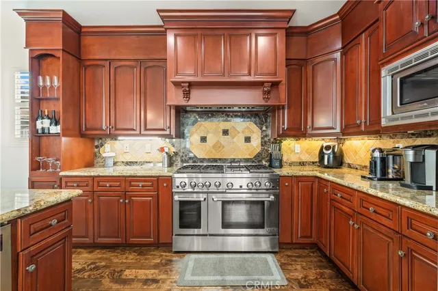 a kitchen with stainless steel appliances granite countertop a stove and cabinets