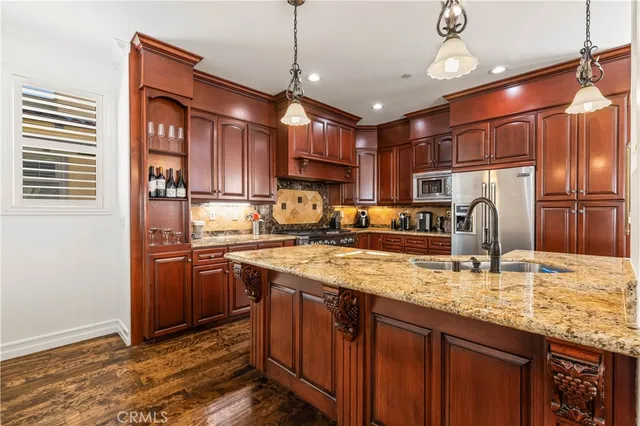 a kitchen with stainless steel appliances granite countertop a sink refrigerator and cabinets