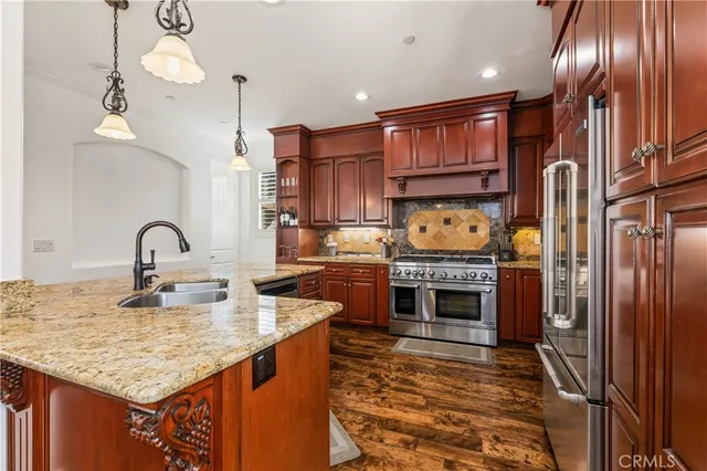 a kitchen with stainless steel appliances granite countertop a stove a sink and a refrigerator