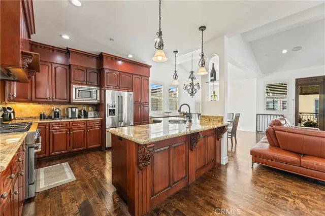 a kitchen with stainless steel appliances granite countertop a sink a stove and a refrigerator
