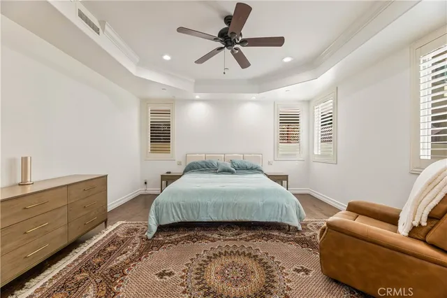 a spacious bedroom with a bed a couch and a ceiling fan