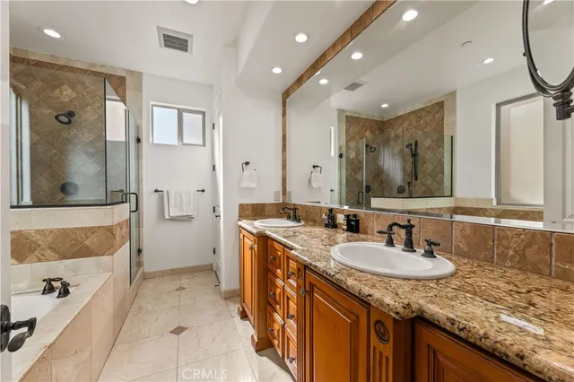 a bathroom with a granite countertop sink a mirror and a bathtub