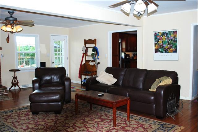 170 Tate Road Sewanee, TN 37375 - Photo 8 of 20 Another angle of living room, towards deck entrance, hardwood floors and brick wood burning fireplace
