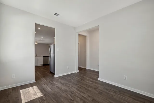a view of a room with wooden floor and a bathroom