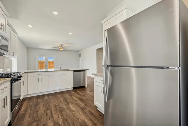a kitchen with a refrigerator and white cabinets