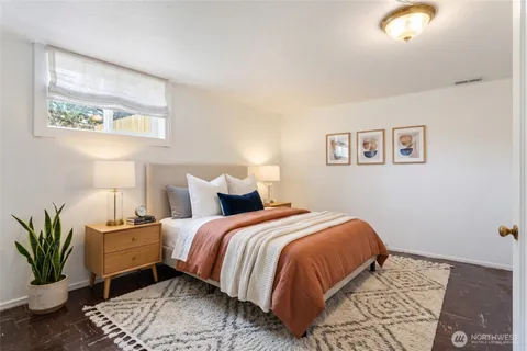 a bedroom with bed and a painting on the wall