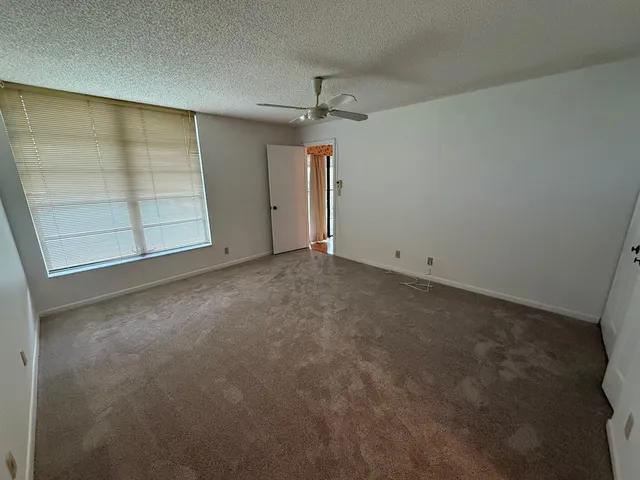 an empty room with closet and windows