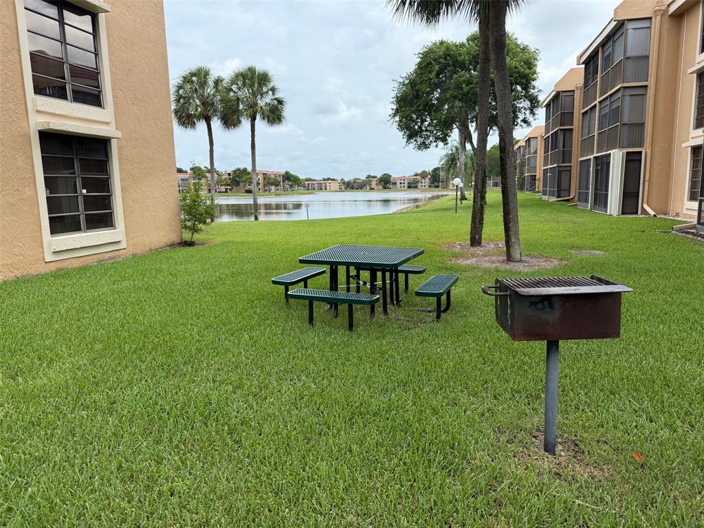 6215 Coral Lake Drive, Unit 203 Margate, FL 33063 - Photo 35 of 46 a backyard of a house with table and chairs