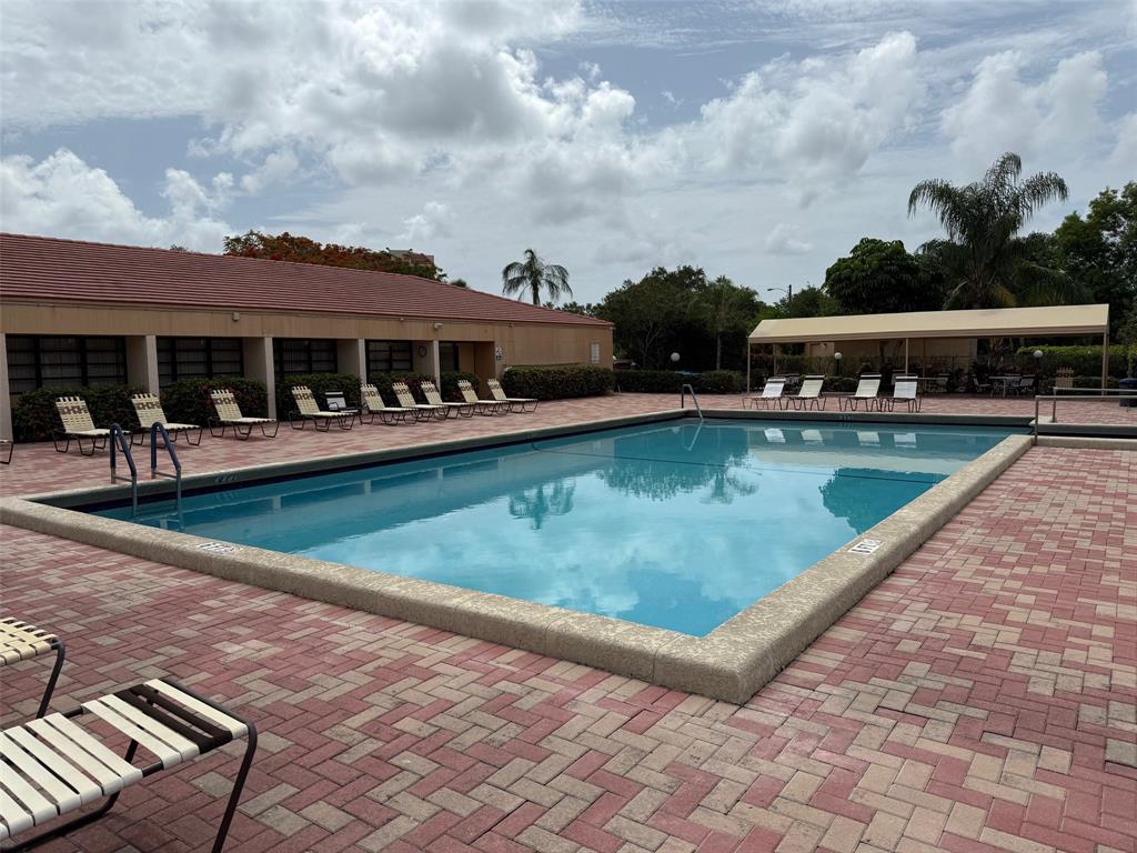 6215 Coral Lake Drive, Unit 203 Margate, FL 33063 - Photo 40 of 46 a view of a swimming pool with lounge chairs in front of house